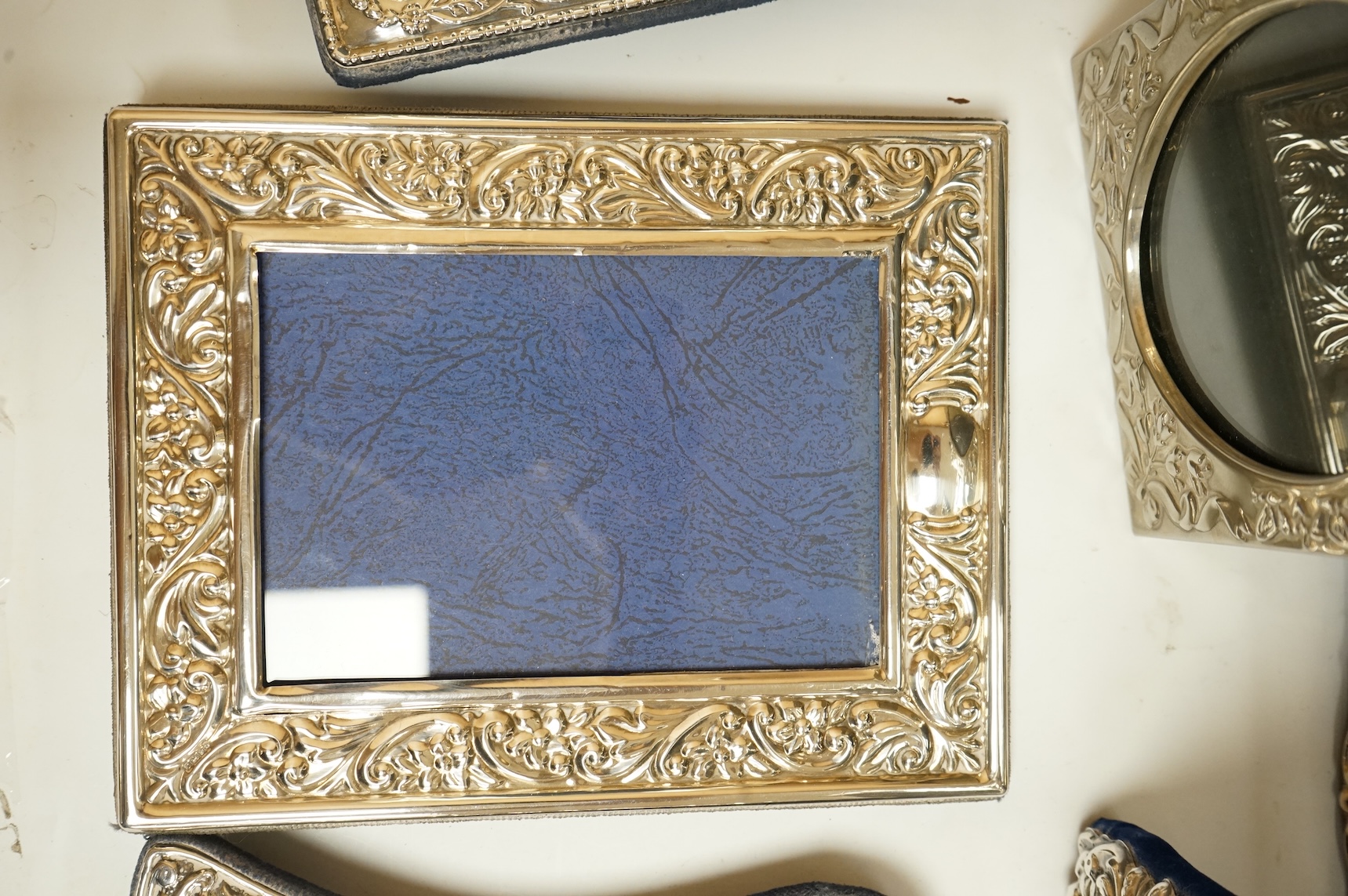 A George V silver mounted rectangular photograph frame, with ribbon bow crest, by Stokes & Ireland Ltd, Chester, 1912, 18.2cm including crest, together with ten other modern silver mounted photograph frames, largest 29.4